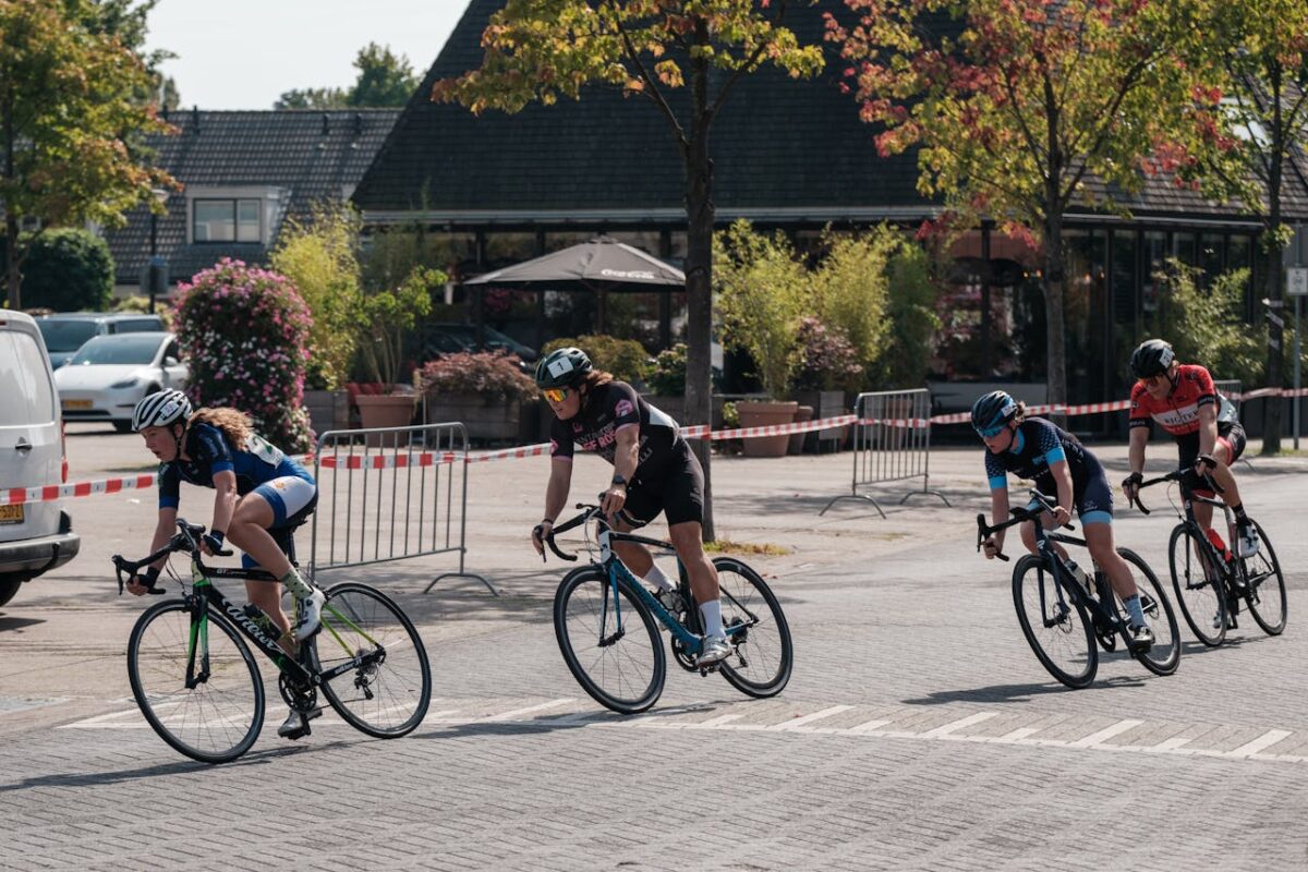 Cyclists in a competitive street race on a sunny day, showcasing speed and determination.