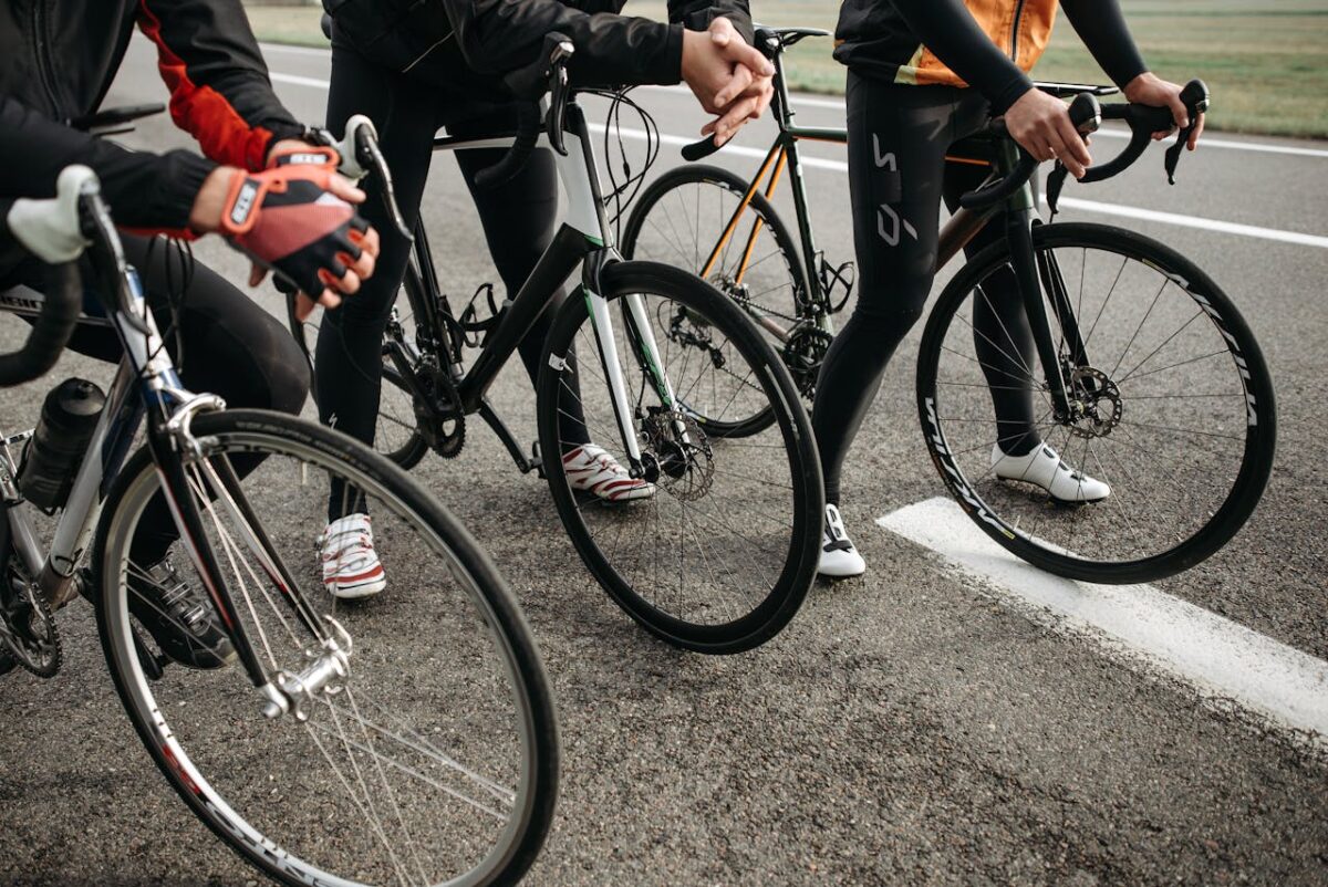 Group of cyclists with modern road bikes getting ready for a competitive ride on asphalt road.